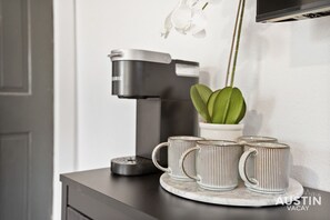 Keurig maker with coffee mugs and a few kitchen basics