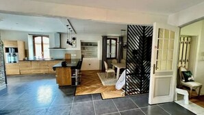 Een ruime woonkamer met een keuken, eettafel en een apart zitgedeelte.