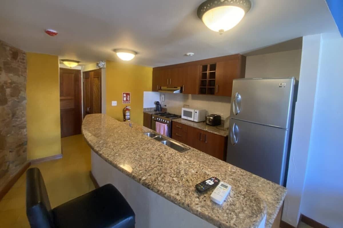 A kitchen with granite countertops, stainless steel appliances, and wooden cabinets.