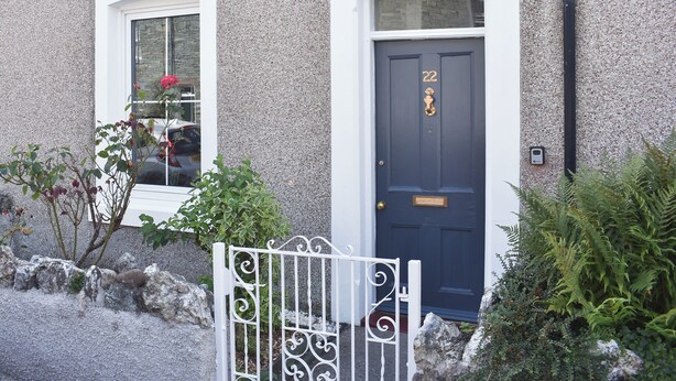 A house with a dark blue door marked with the number 22, a white picket fence, and a stone wall. - 2 bedroom accommodation in Keswick (Keswick)