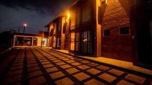 Um edifício com piso xadrez, janelas amplas e fachada de tijolos.