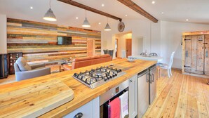 Eine moderne Küche mit einer Holztheke, einem Einbauofen und einem Essbereich mit einer Couch.