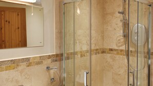 A modern bathroom with a glass-enclosed shower, a white sink, and a wooden panel wall. - Pitcairn House-UK41255 (Keswick)
