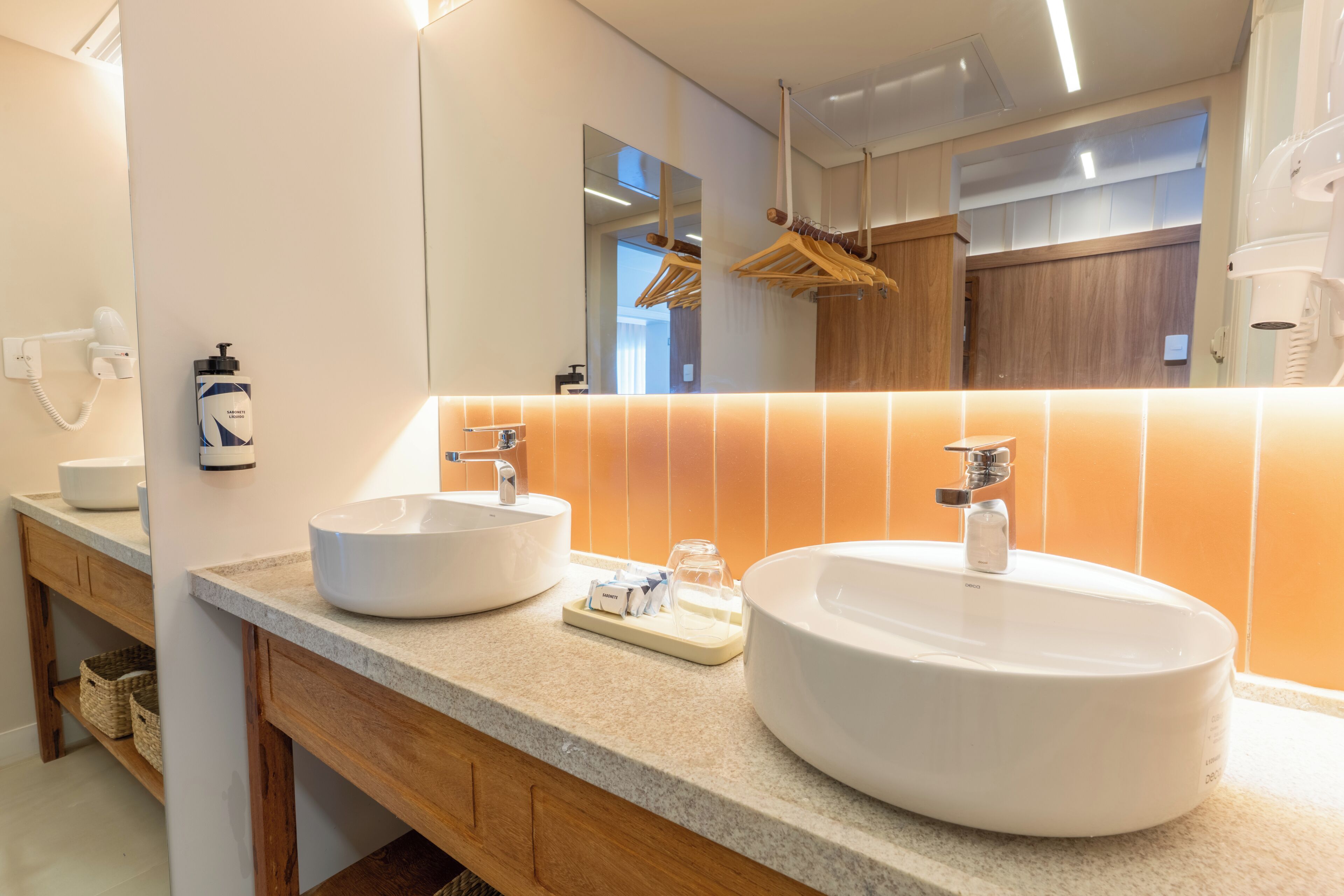 Ein Badezimmer mit zwei Waschbecken, einem Spiegel und einem Handtuchhalter.