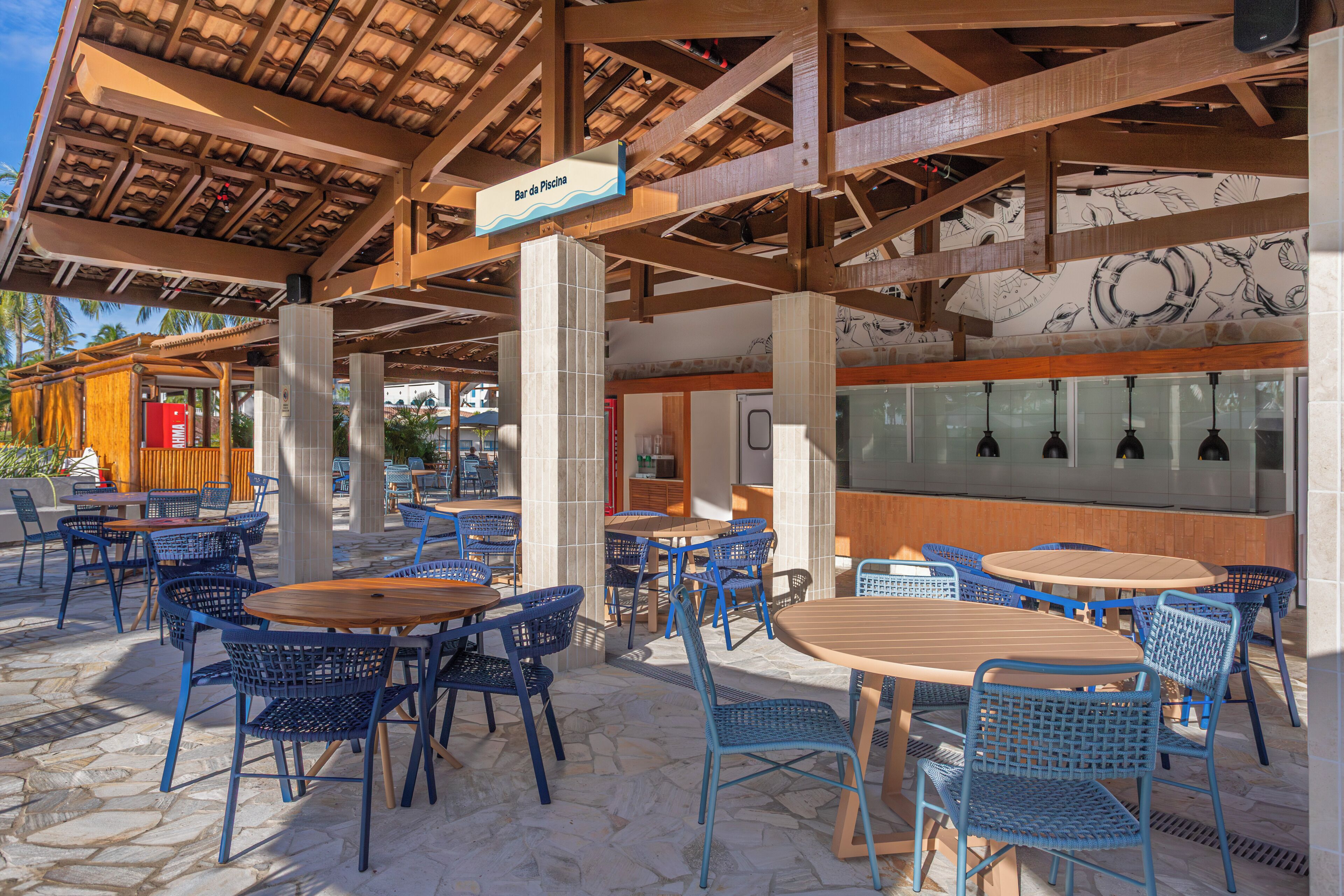 Un espace café en plein air avec des tables et des chaises, un plafond en bois et une enseigne indiquant « Bar da Piscina ».
