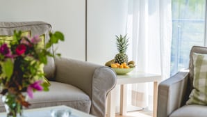 A modern living room with a sofa, a small table with a fruit bowl, and a floor lamp. - Lakeview 2 Lake Salem child-friendly bathing lake W LAN (Salem)