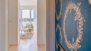 A hallway with a view to a balcony, a patterned wall, and a door leading to a room. - Lakeview 2 Lake Salem child-friendly bathing lake W LAN (Salem)