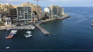 Paisaje costero con un puerto deportivo, barcos y un muelle.