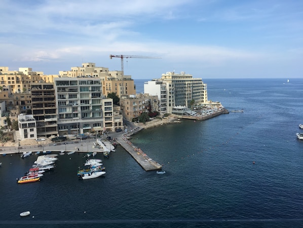 A coastal cityscape with a marina, including boats and a pier. - Seafront Penthouse Triplex- Roof Terrace & Hot Tub (St. Julian's)