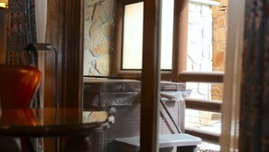 A room with a stone wall, a window, and a view of an outdoor area. - Luxury Three Bedroom Suite with Mountain Views and Three Hot Tubs 3 Apartment Hotel by RedAwning (Park City)