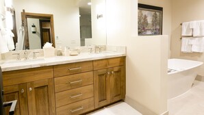 A modern bathroom with a wooden vanity, a large mirror, a bathtub, and a shower area. - Deluxe King Room With Deck Hotel Room by RedAwning (Park City)