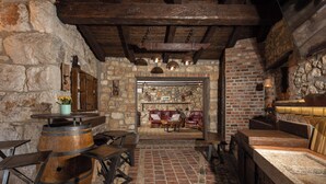 A rustic interior with stone walls, wooden furniture, and a brick floor. - Villa Cupido With Private Pool (Vinodol)
