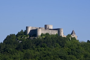 A castle on a hill with a tower and a smaller building. - Villa Cupido With Private Pool (Vinodol)