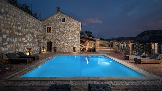 A stone building with a swimming pool, lounge chairs, and a bar area. - Villa Cupido With Private Pool (Vinodol)