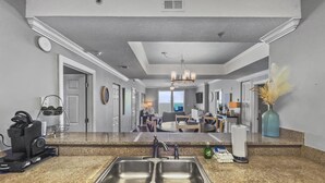 A modern kitchen with granite countertops, a double sink, and a built-in dishwasher. - Ocean Ritz-501 4 Bedroom Condo by RedAwning (Panama City Beach)