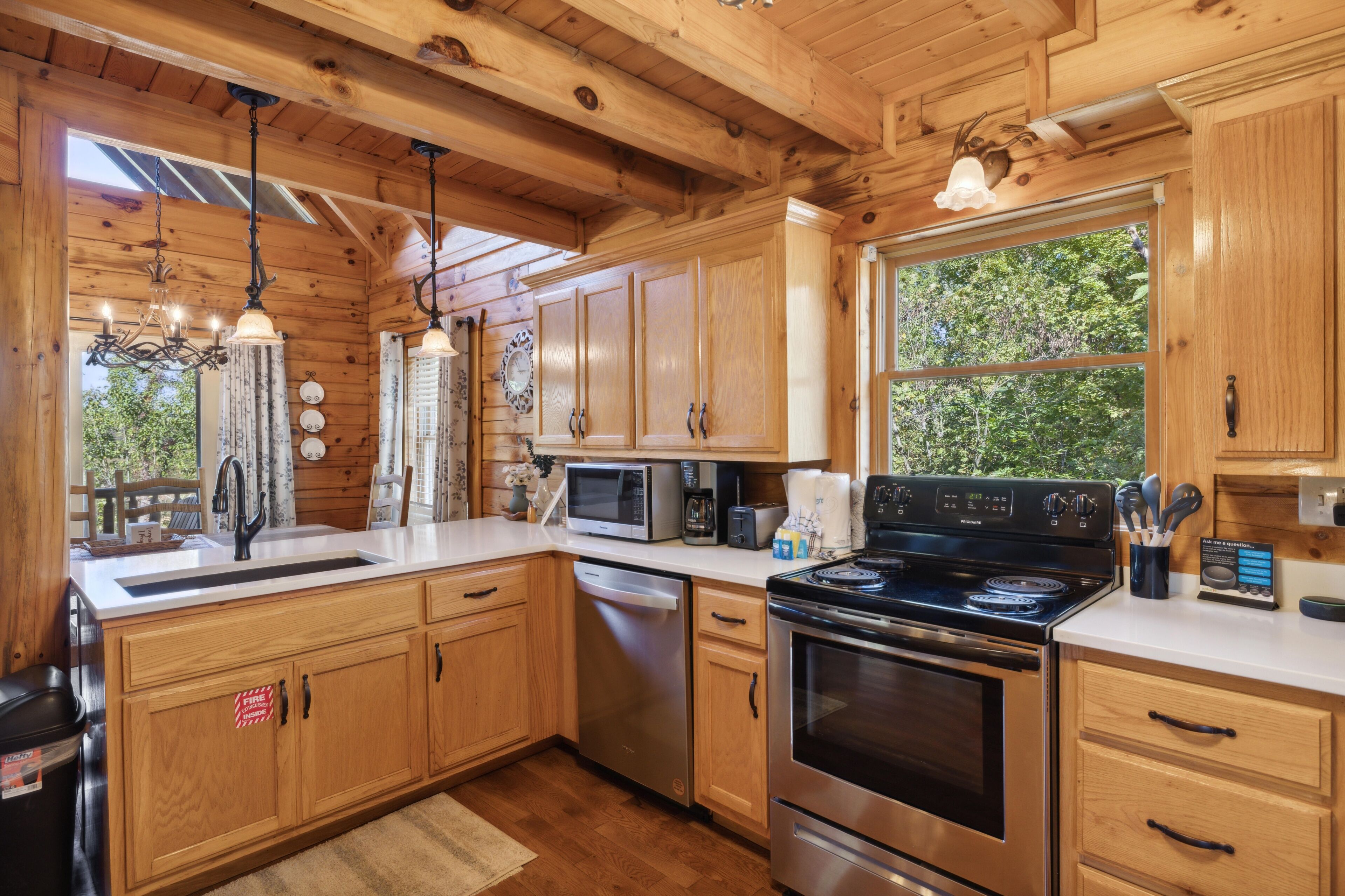 Cocina de cabaña de madera con una estufa grande, un microondas y un lavamanos.