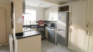 Een moderne keuken met roestvrijstalen apparatuur, witte kasten en een inbouwoven.