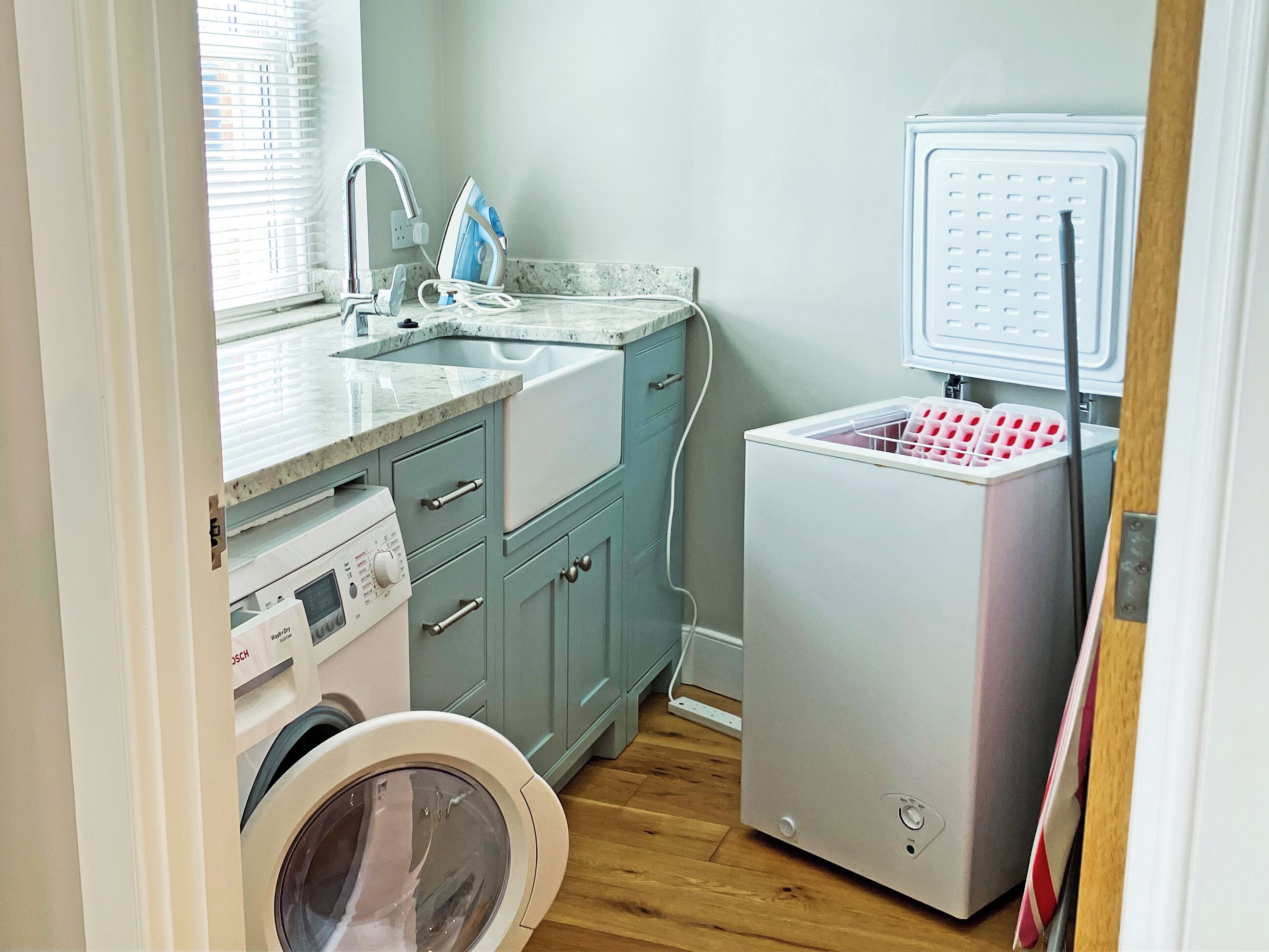 Une cuisine compacte équipée d’un lave-linge, d’un four encastré et d’un réfrigérateur.