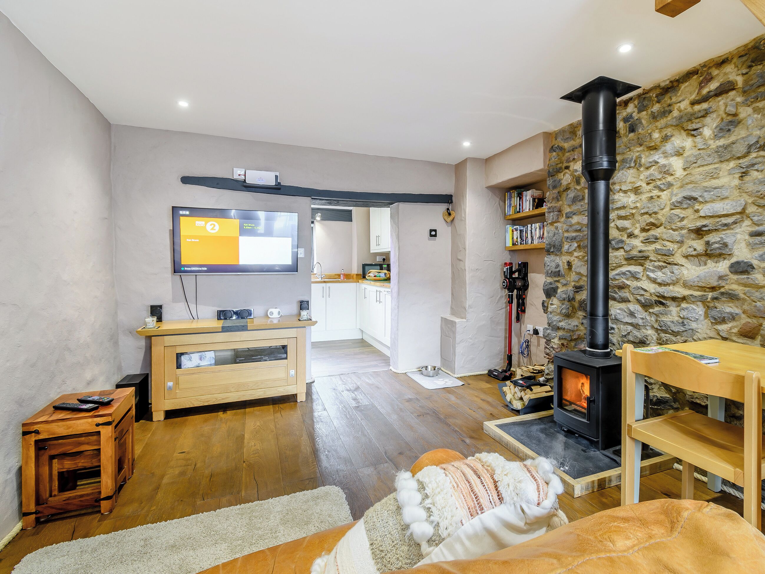 Una sala de estar acogedora con chimenea, muebles de madera y televisor.