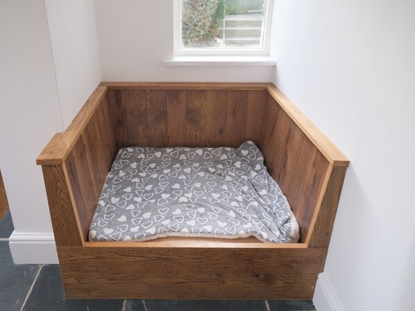 A wooden bench with a grey blanket featuring a heart pattern.