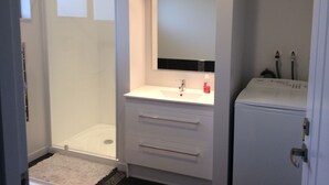 A bathroom with a shower, a sink, and a mirror. - Glenorchy rise (Glenorchy)