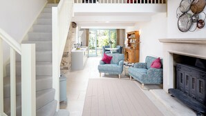 A spacious living area with a staircase, a fireplace, and a dining area. - 1 bedroom accommodation in Old Sodbury, near Bristol (Old Sodbury, near Bristol)