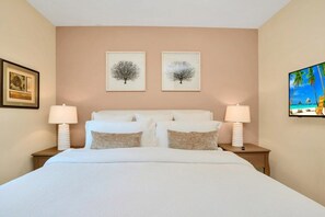 Relax in comfort with a large bed, two nightstands, and beautiful artwork adorning the walls.
