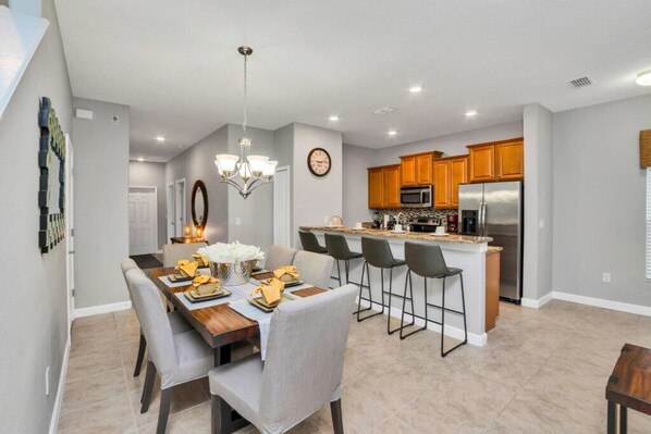 Enjoy meals in the kitchen and dining area, featuring a central island, wooden cabinets, and a dining table for four.