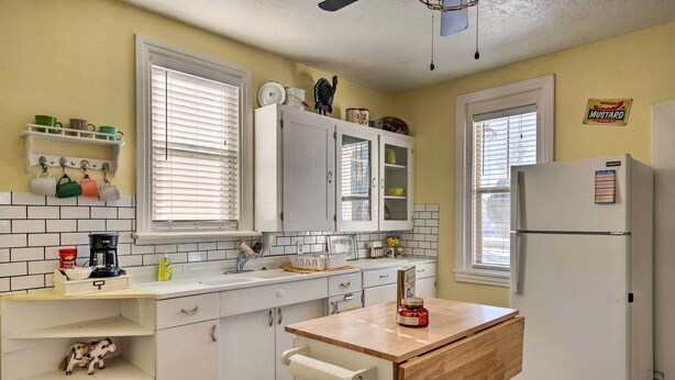 A kitchen with white cabinets, a wooden countertop, a refrigerator, and a window with blinds. - Kik-N-Bak Cottage w/ Beautiful Mountain View (Manti)