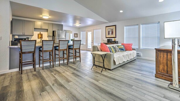 A spacious living area with a kitchen, dining area, and a sofa with colorful cushions. - Cozy Darrington Cottage w/ Grill, Near Trails (Darrington)