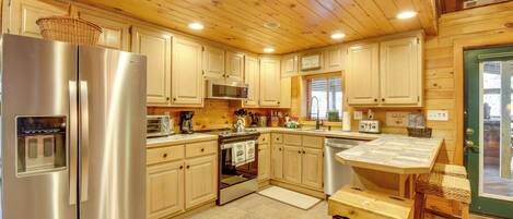 A modern kitchen with wooden cabinets, stainless steel appliances, and a green door.