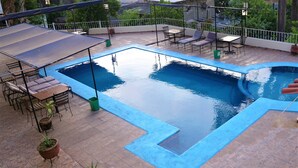 A rooftop pool with a blue border, surrounded by outdoor furniture and potted plants. - Casa Rinconsito Miramar (Santa Cruz)