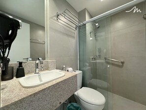 A modern bathroom with a sink, toilet, and glass-enclosed shower.