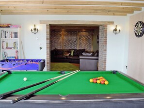 A pool table with cues and balls, a foosball table, a bookshelf, and a dartboard in a room with brick walls and wooden beams. - 5 bedroom accommodation in St Clears, near Laugharne (St Clears, near Laugharne)