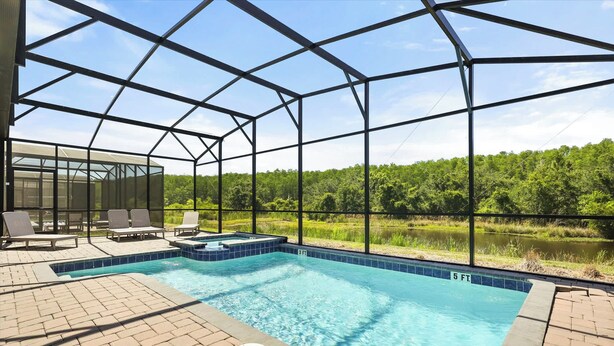 Una piscina techada con vistas a un lago y un bosque.