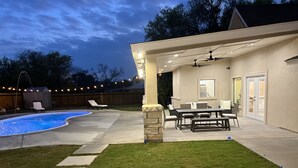 A backyard with a swimming pool, patio furniture, and a covered outdoor area with a ceiling fan. - Casa Recuerdos (Del Rio)