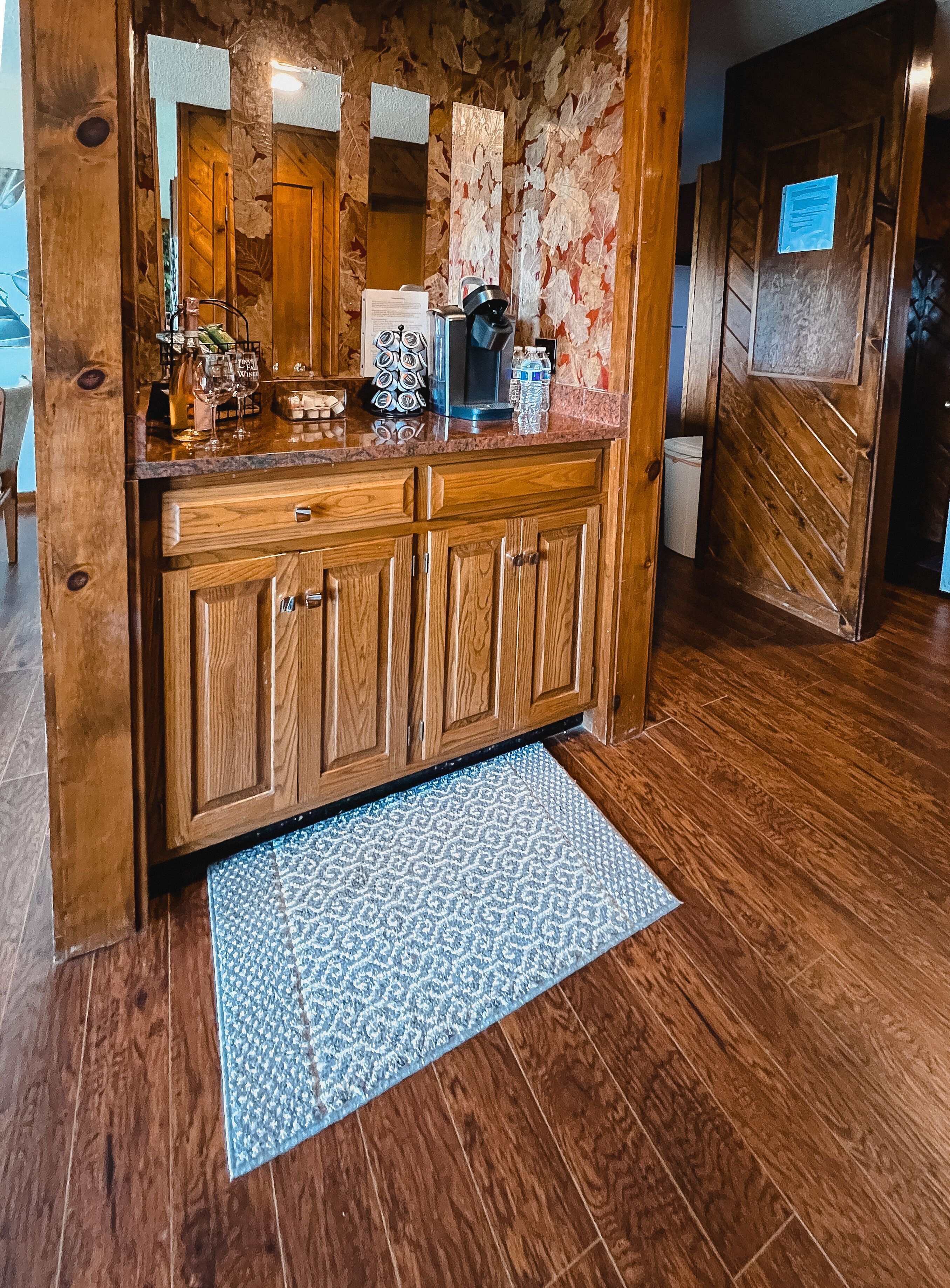 A wooden cabinet with a built-in microwave, a coffee maker, and various kitchen items.