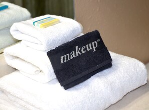 A stack of white towels with a black label that reads "makeup".