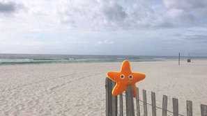 A beach with a wooden fence and a starfish decoration. - Paradise Palms Edgewater T3-Beachfront-1 BD/1BTH-Sleeps 4-Mesmerizing Views! (Panama City Beach)