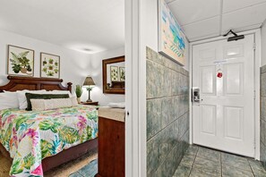Une chambre d’hôtel équipée d’un lit, d’une table de chevet, d’une lampe et d’une porte dotée d’un système de verrouillage à carte magnétique.