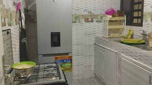 A compact kitchen with a gas stove, a refrigerator, and a sink. - Luxury apartment in the center of Abidjan (Abidjan)