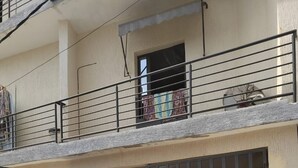 A residential building with a gated entrance, a balcony with a railing, and a visible window. - Luxury apartment in the center of Abidjan (Abidjan)