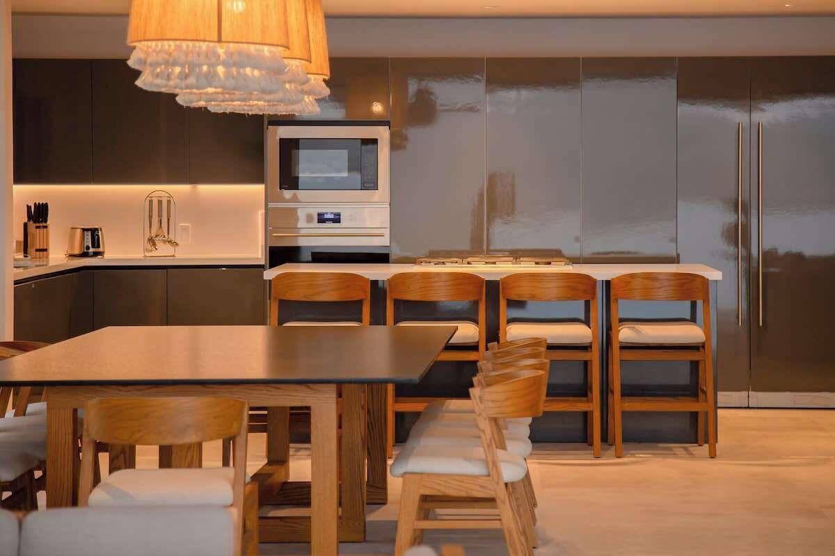 Une cuisine moderne avec des meubles en bois, un four encastré et une grande fenêtre.