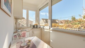 A small kitchen with a window, a sink, and a microwave.