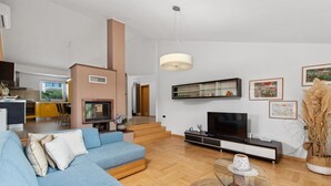 A modern living room with a sofa, TV, and fireplace. - Villa Vintiana - Private Pool, Six Bedrooms (Vintijan)