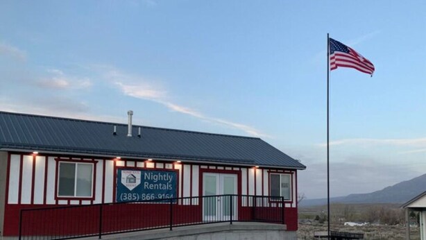 Ein Gebäude mit einem Schild für 'Nightly Rentals' und einer US-amerikanischen Flagge.