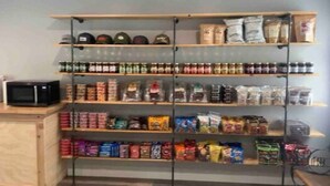 A storage area with shelves holding various food items and a microwave on the left. - Home Base Resort  #5 (Joseph)