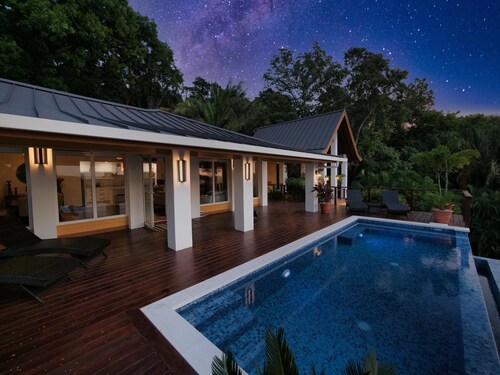 Relax at this hillside retreat that overlooks the lush forest and the Caribbean.