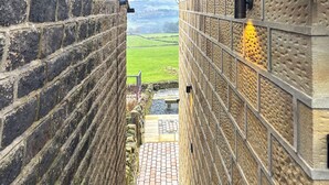 A stone staircase leading to a view of a green landscape. - Sykes Head Cottage - UK42147 (Oakworth)