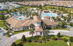 Un gran resort con varias edificaciones, una piscina central y vegetación circundante.